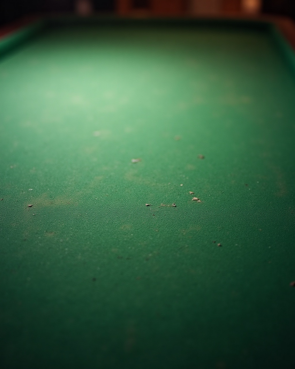 Close-up of a worn green baize gaming table surface